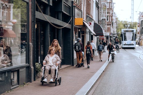 A woman pushing a stroller down a city street