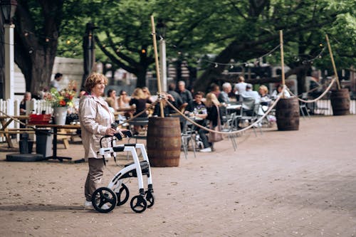 A woman walking with a baby stroller in a park