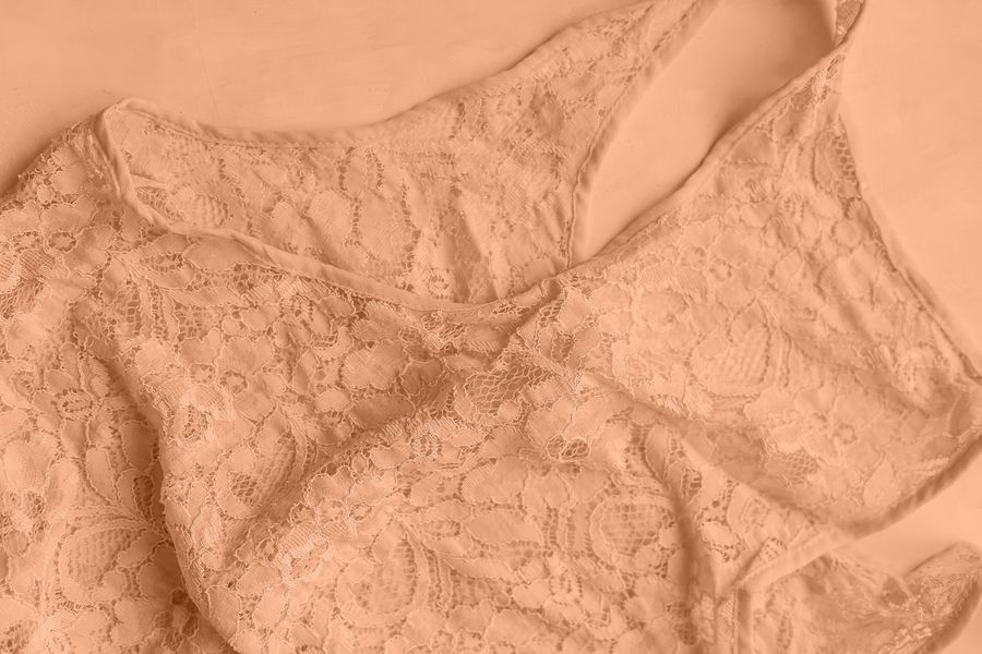 Close-up photo of delicate lace lingerie in soft beige tones, perfect for fashion and elegance themes.