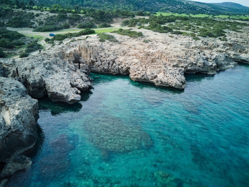 Free Stunning aerial view of the rocky coastline and turquoise waters in Neo Chorio, Cyprus. Stock Photo