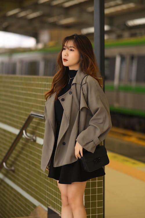 Woman in Mini Skirt and Coat Stands on Platform