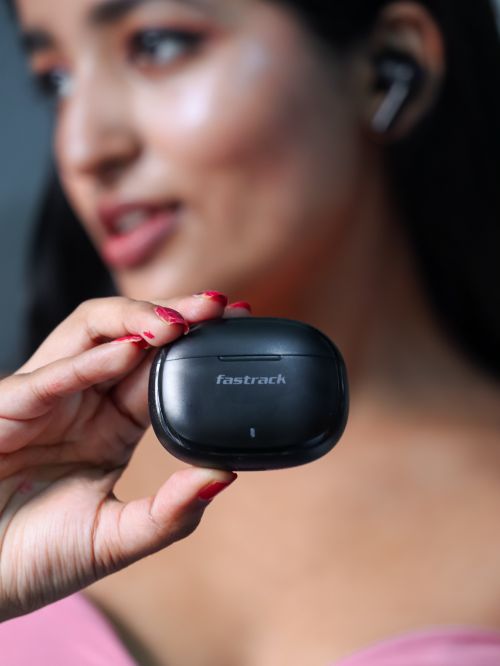Free Close-up of a woman holding a black earphone case, showcasing modern wireless technology. Stock Photo