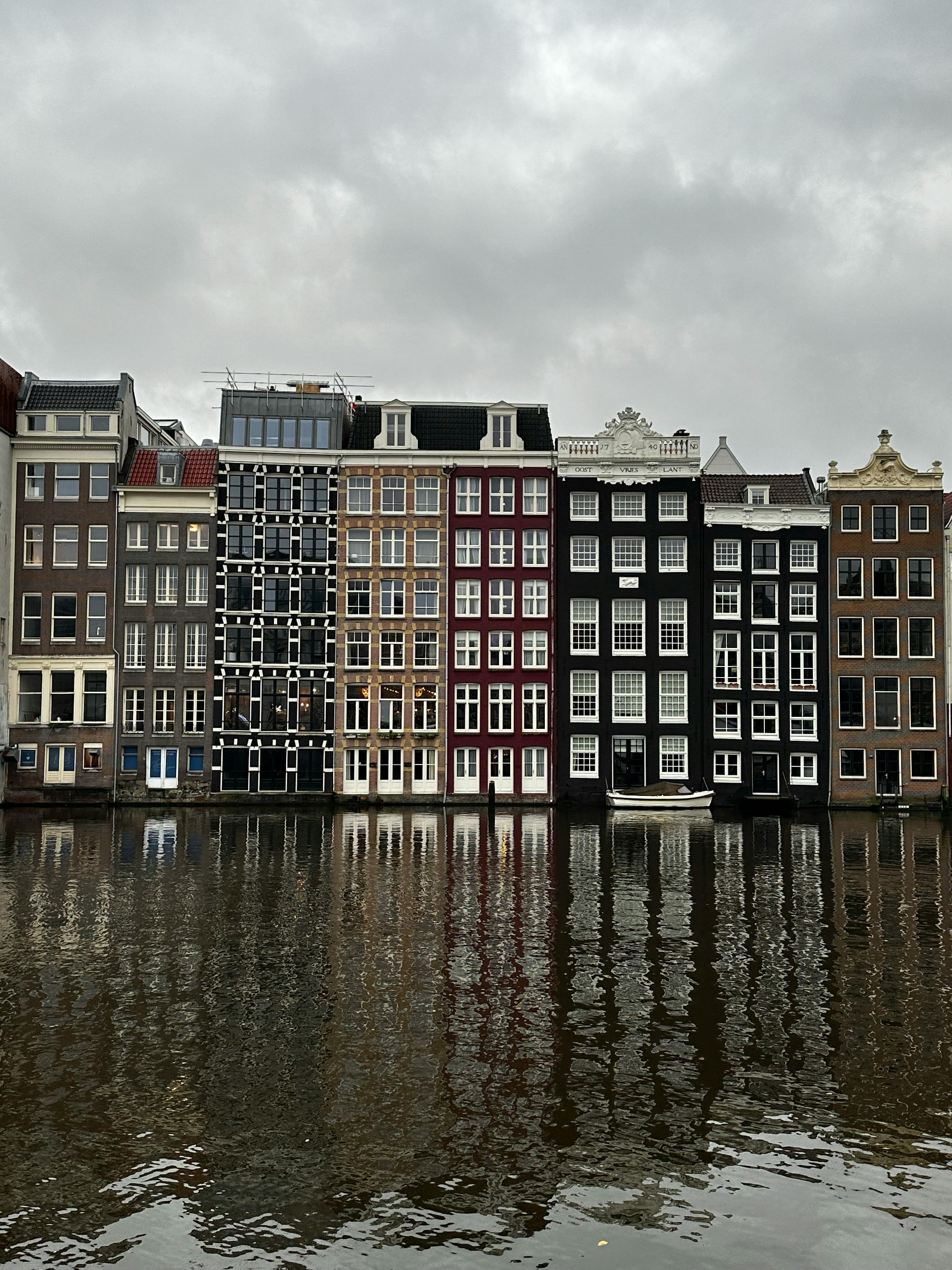 facade of tenements by canal in amsterdam