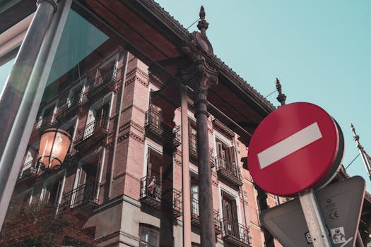 玻璃上倒映着马德里的经典建筑，旁边还有明显的禁止进入标志