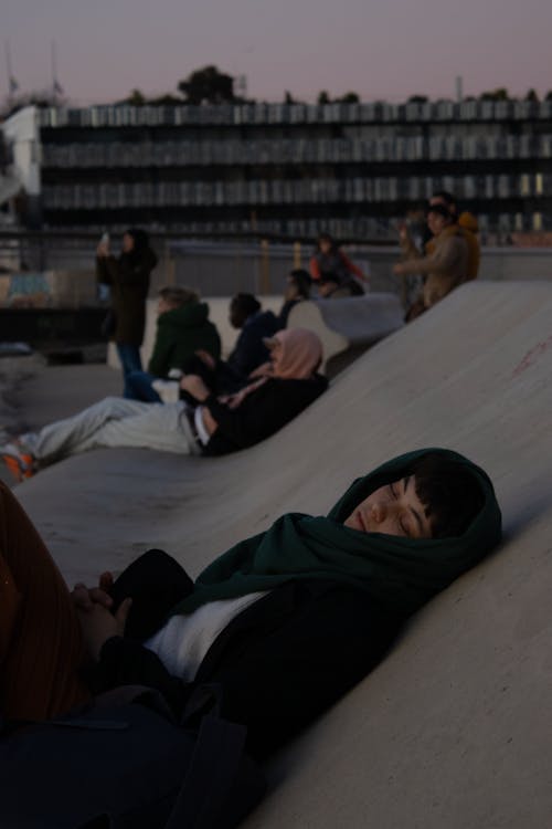 People Lying Down on Wall in City