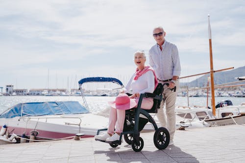 Man with Woman on Wheelchair on Promenade on Coast