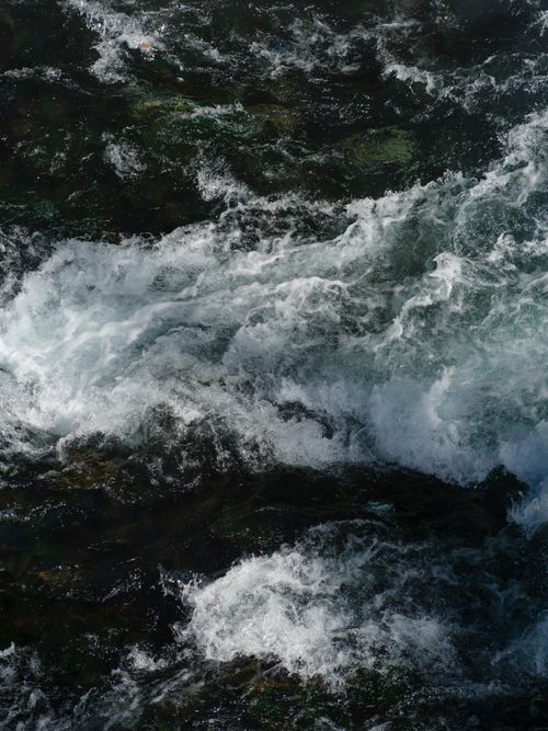 Free Aerial view of ocean waves crashing on rocky shore, showcasing nature's power and beauty. Stock Photo