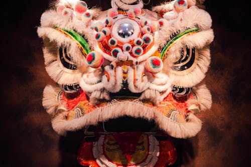 A chinese lion head mask with colorful decorations