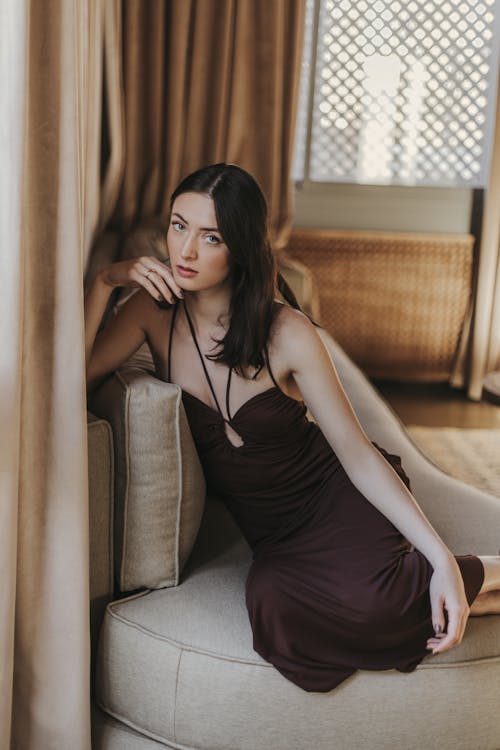 Model in Brown Dress Sitting on Couch