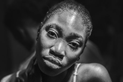 Close-up monochrome portrait of an African woman captured in Jos, Nigeria. Strong emotional expression.