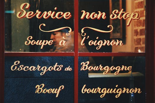 Classic French bistro window showing traditional menu items with reflections.