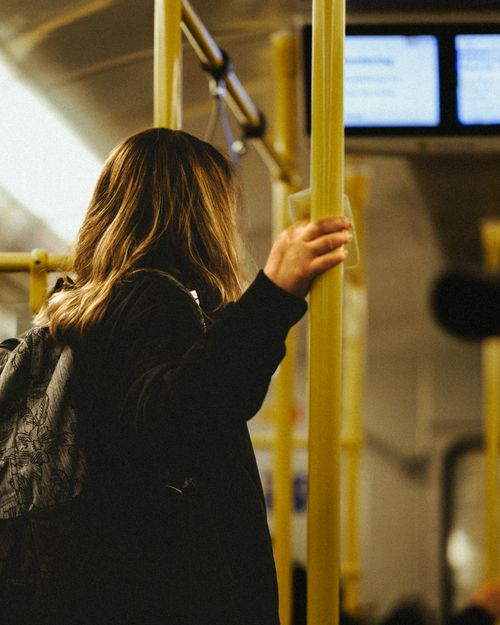Free Woman holding a pole inside a tram in Berlin with a focus on public transportation and everyday commute. Stock Photo