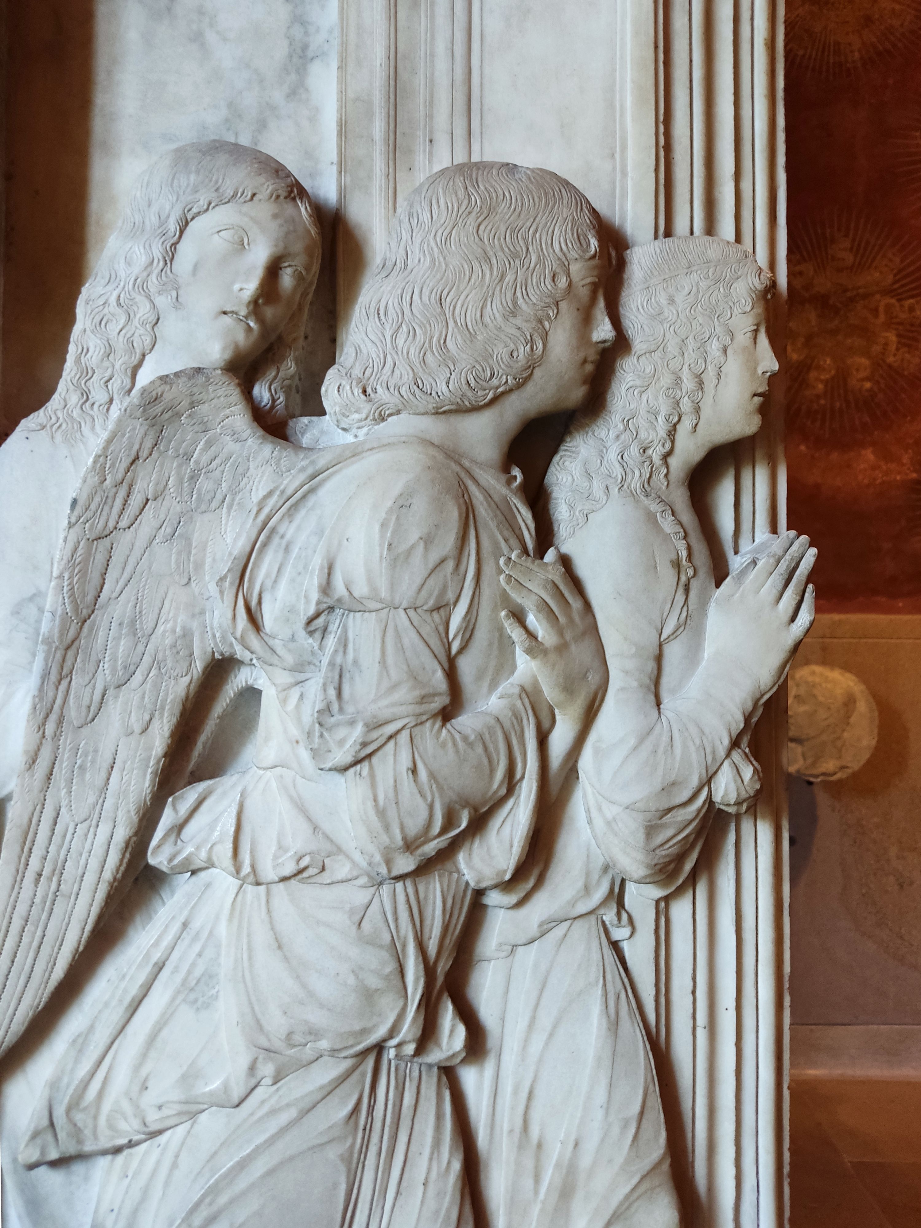 Intricate marble relief of angels at Sforzesco Castle in Milan, Italy; a masterpiece of Renaissance art.