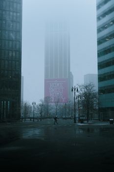 A foggy street in Detroit with buildings enveloped in winter mist, capturing an urban morning.