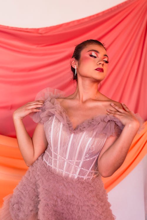 Brunette Woman in Pink Dress Posing with Eyes Closed