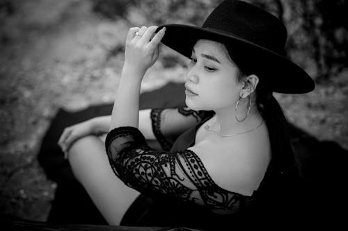 Woman Sitting in Hat in Black and White