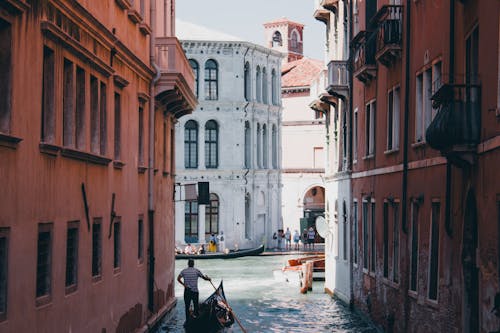 Free Gondolier on Boat on Canal in Venice, Italy Stock Photo