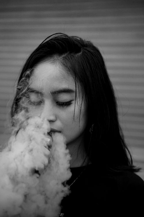 Free Close-up portrait of a woman with closed eyes, engulfed in smoke. Stock Photo