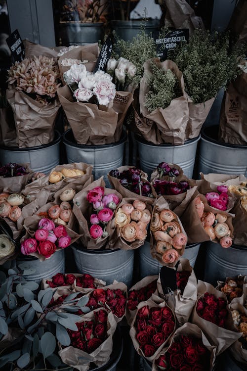 A bunch of flowers in buckets and bags