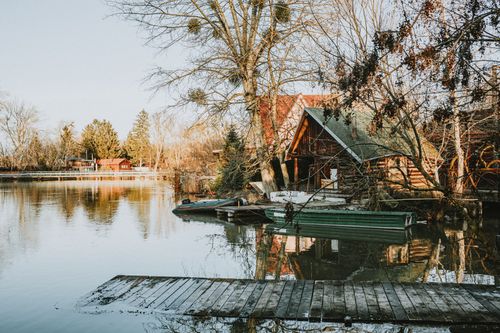 Free A serene rustic lakeside cabin with dock surrounded by fall foliage. Stock Photo