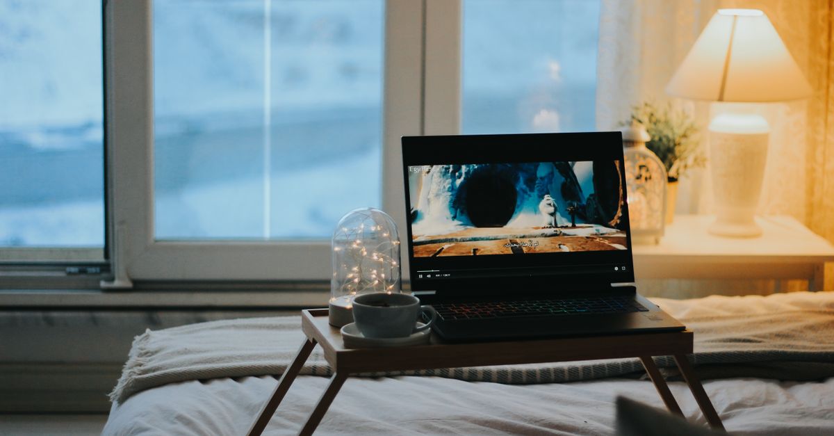 A person journaling or reflecting while watching a movie, cozy atmosphere