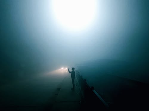 A person standing on a pier in the dark