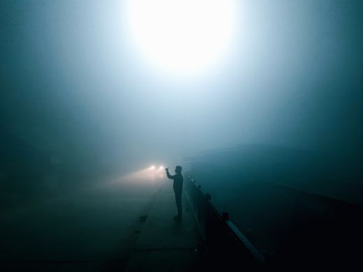 Lone silhouette on a foggy road at night — photo by Muhammed zeya on Pexels