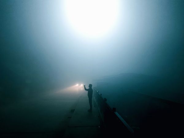 Lone silhouette on a foggy road at night — photo by Muhammed zeya on Pexels