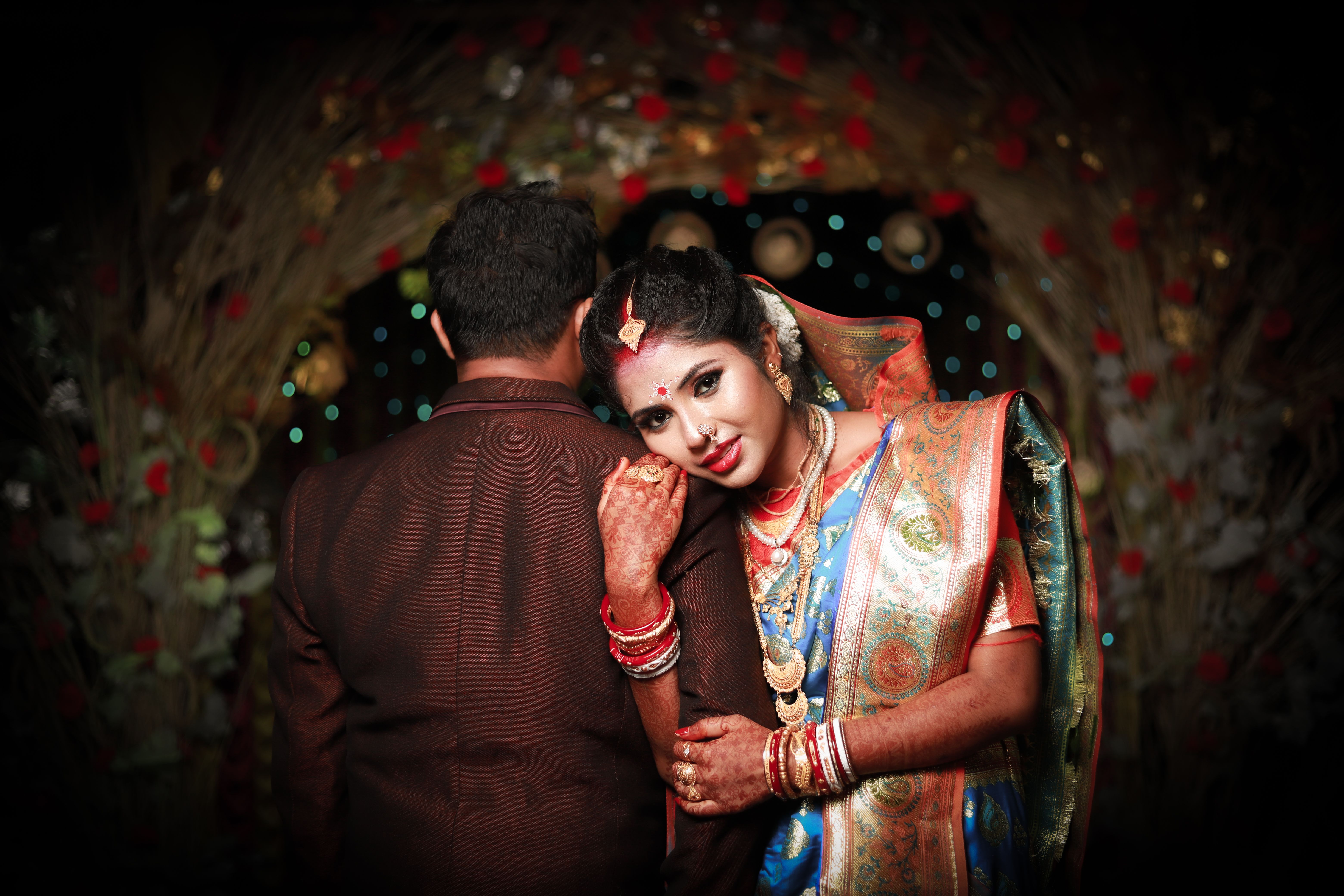 Elegant Indian couple in traditional wedding attire, embracing lovingly.