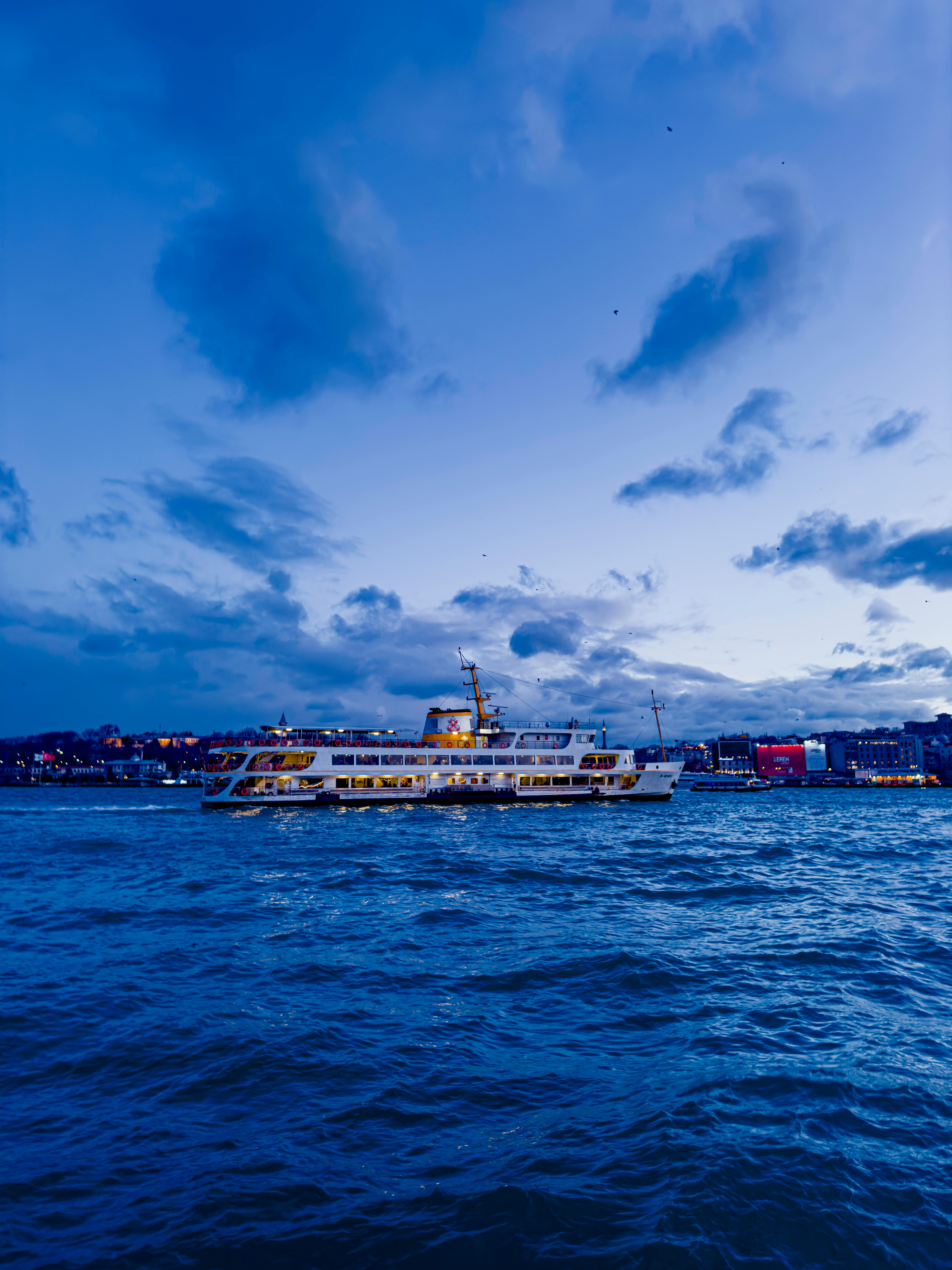 Twilight view of ferry sailing on the Bosporus in Beyoglu, Istanbul, Türkiye.