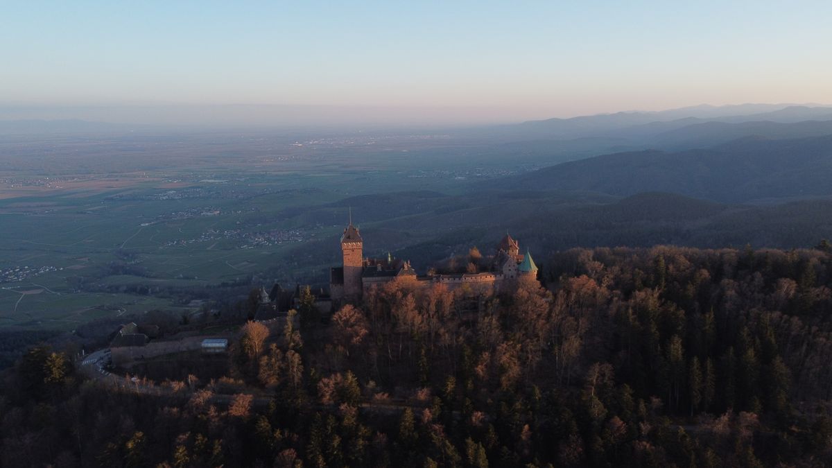 Haut-Koenigsbourg at dusk above forested hills