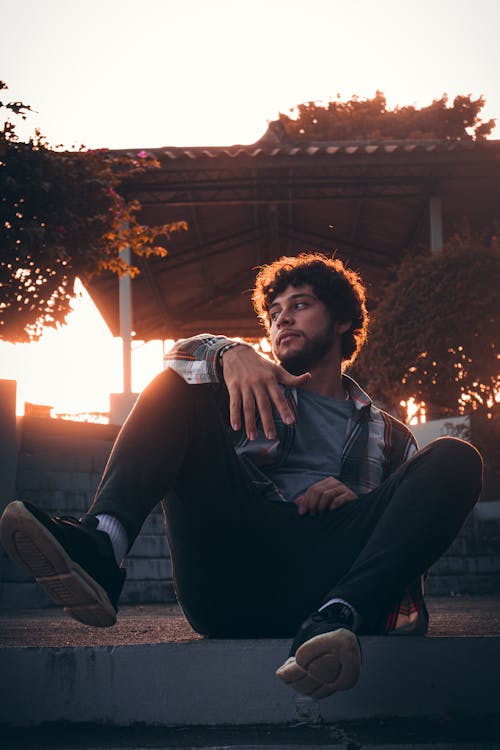 Man Sitting on Wall at Sunset