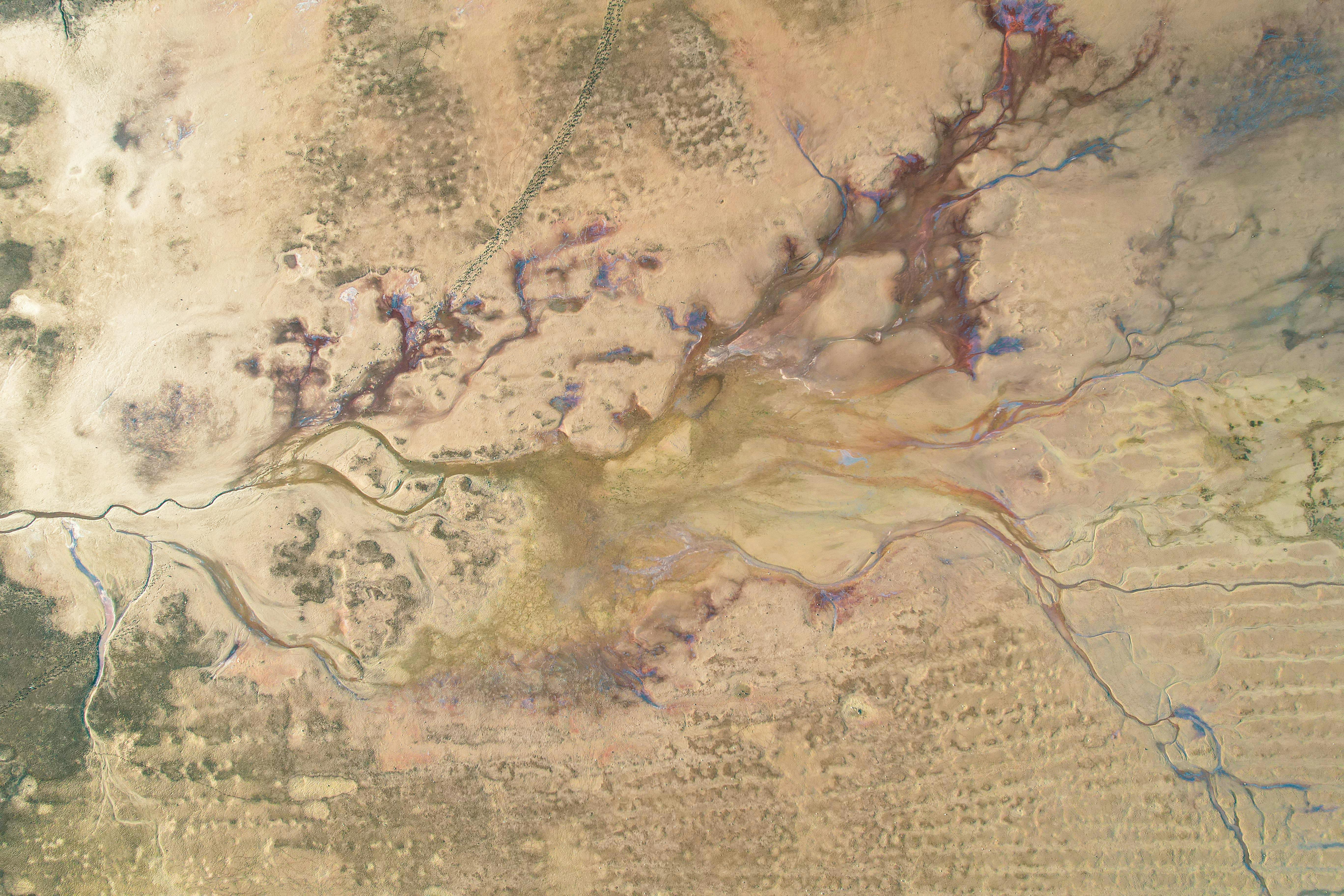 Aerial image showcasing complex natural patterns and earthy tones in rugged terrain.