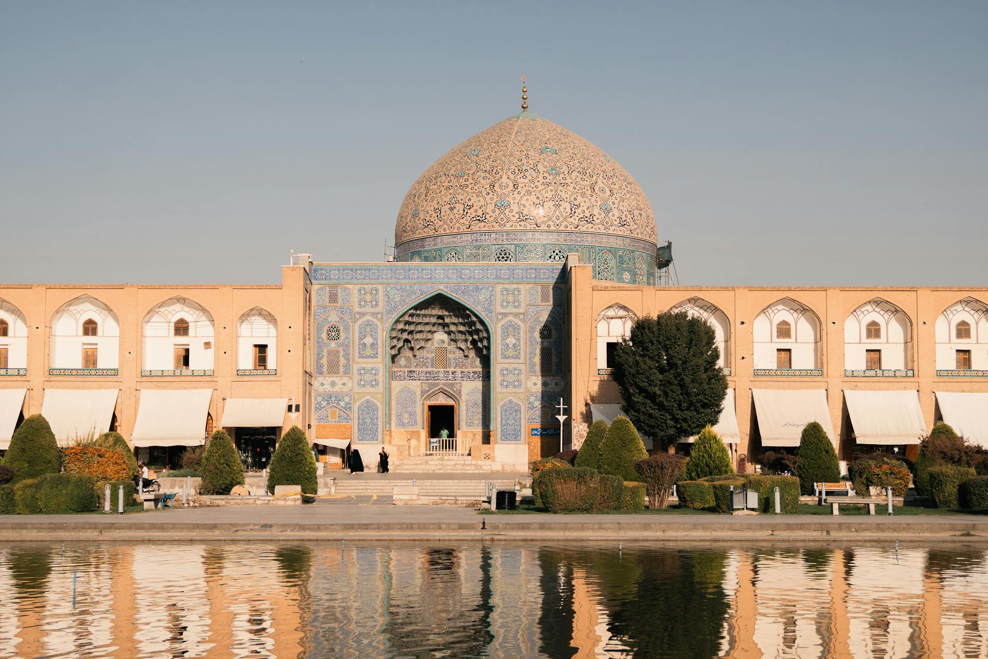 Beautiful view of Sheikh Lotfollah Mosque in Isfahan, Iran reflecting in a pond during the day.