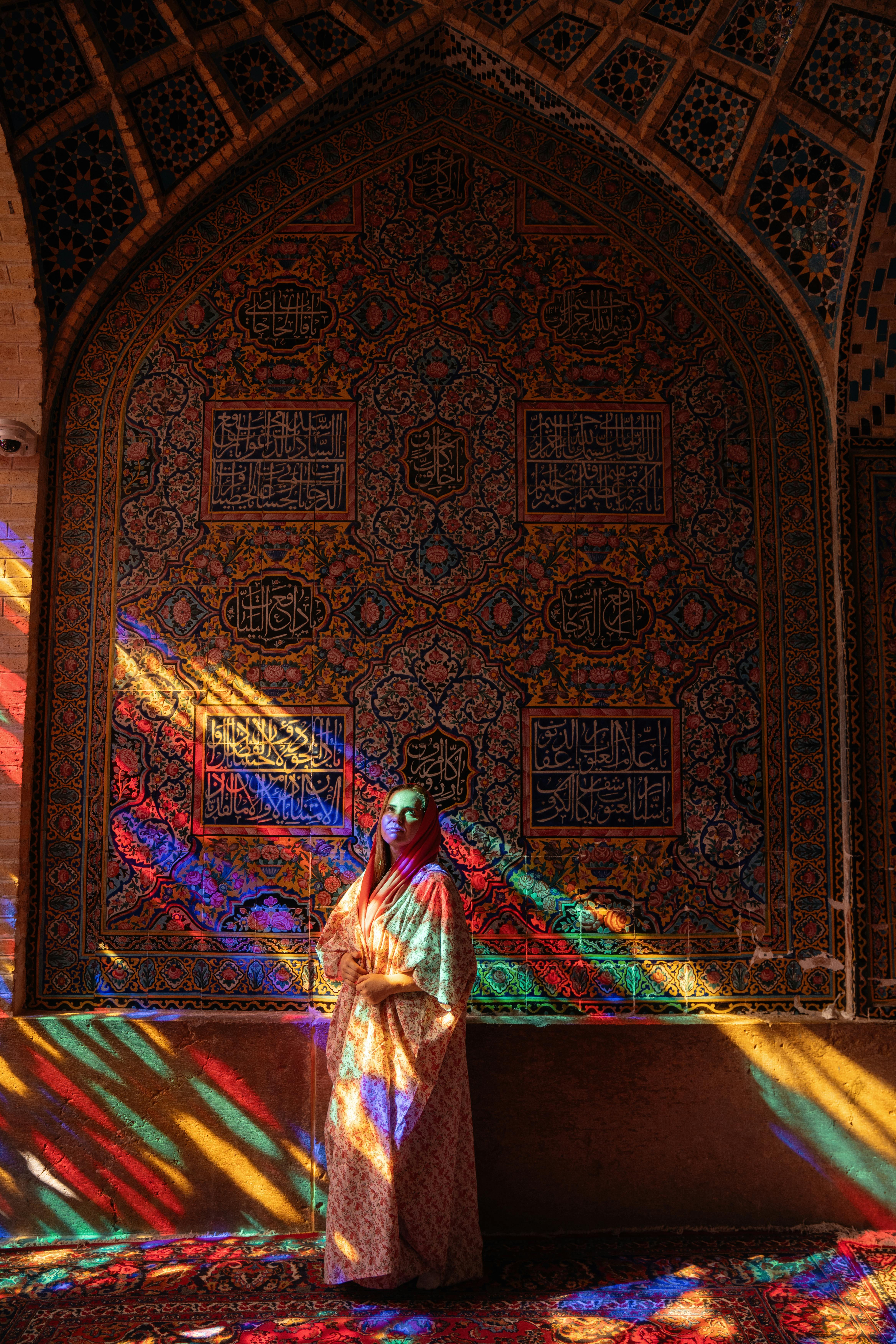 woman standing in pink mosque in iran