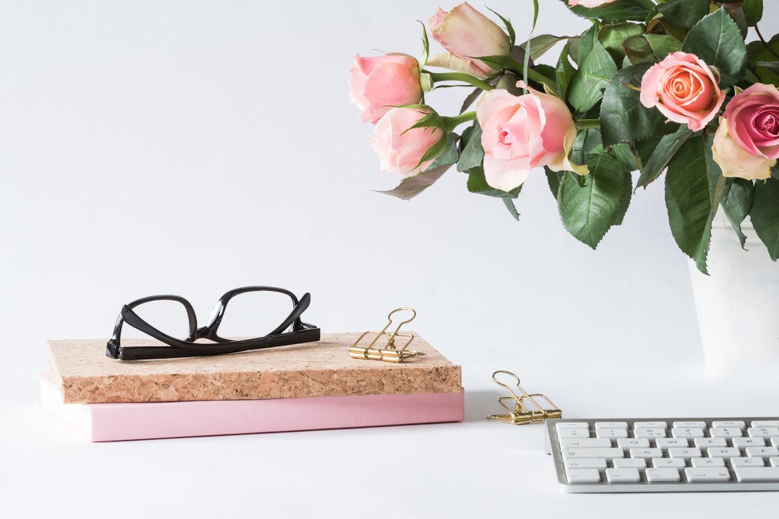 Lunettes Sur Livre à Côté De Rose Et Clavier