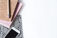 创意工作空间采用时尚的扁平化布局，白色背景上摆放着笔记本、铅笔和智能手机