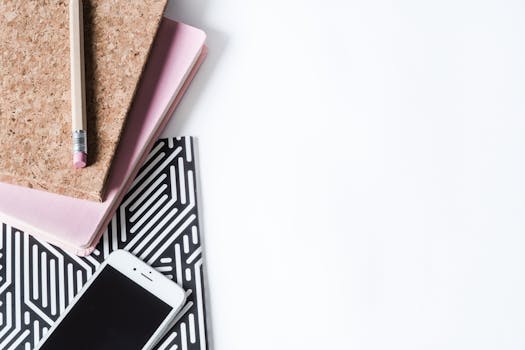 创意工作空间采用时尚的扁平化布局，白色背景上摆放着笔记本、铅笔和智能手机