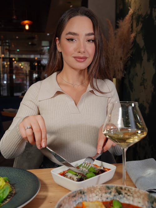 Woman Eating a Meal with a Glass of Wine
