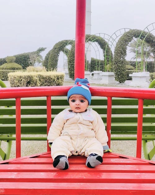 Little cute Baby Boy sitting on a Bench 