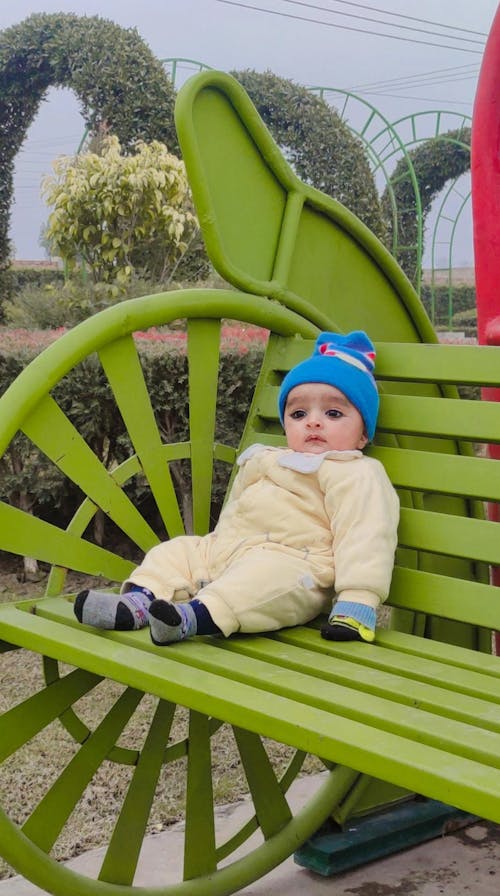 Little cute baby sitting on a bench 