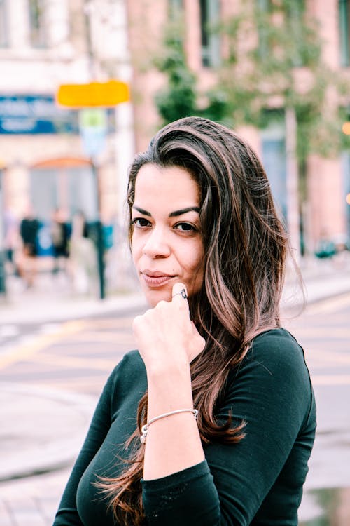 A Woman Standing on a Street in City 