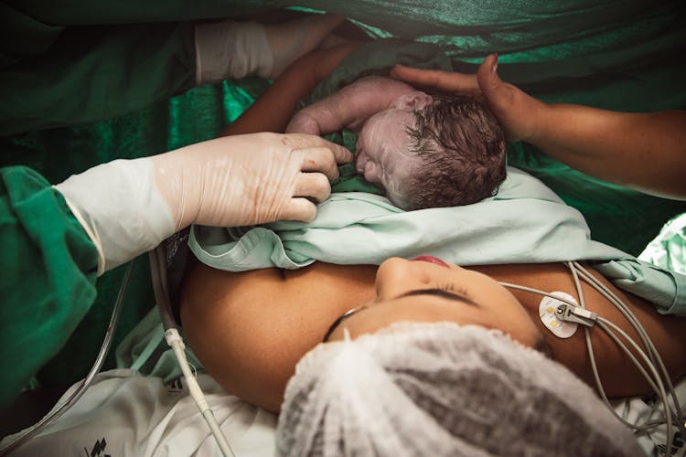 Nurse By Mother With Newborn