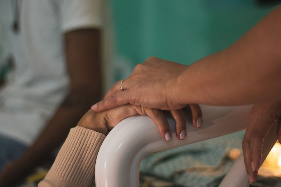 Compassionate hands holding a patient's hand in a hospital — deciding whether ibogaine is right for you starts with medical screening and an honest assessment of your situation