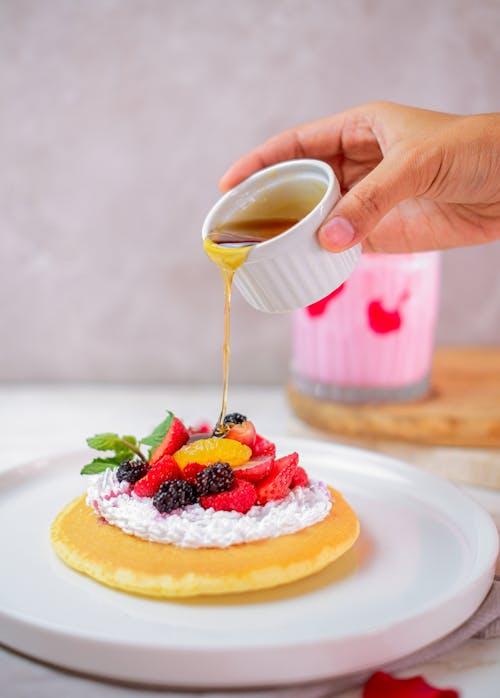 Man Pouring Honey on Pancake