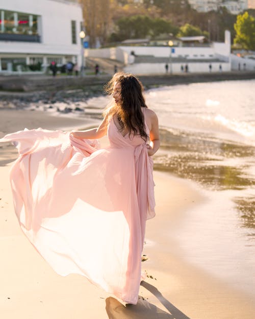 Woman Wearing Pink Dress Walking on a Street 