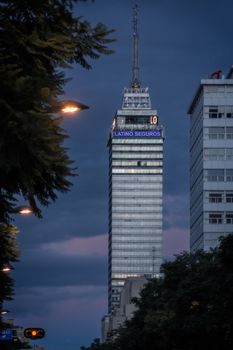 Evening view of the iconic Latin American Tower in Mexico City against a dramatic sky.