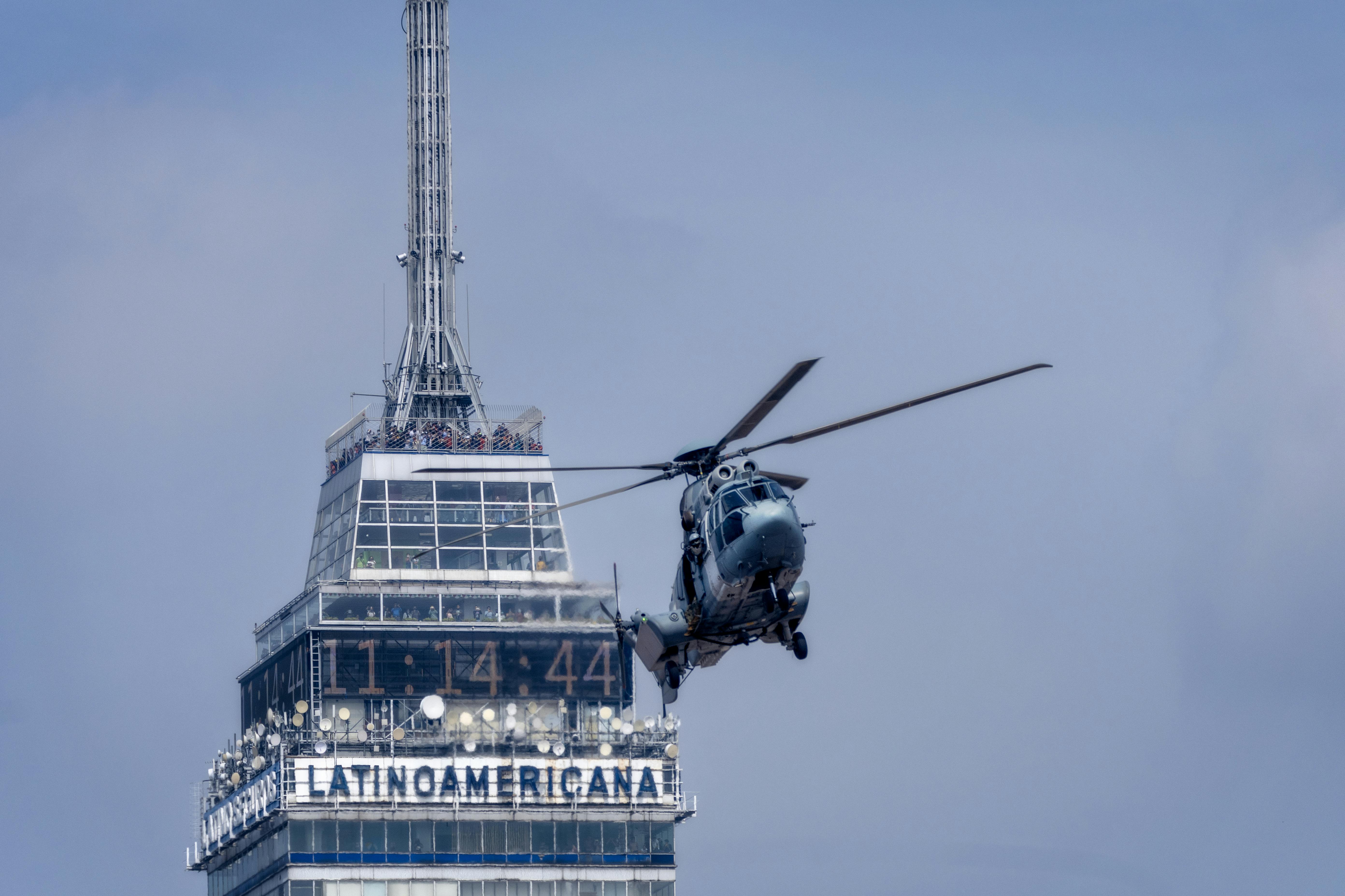 helicopter flying over top of torre latinoamericana