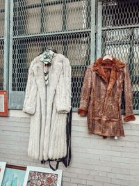 Vintage coats hung against a painted brick wall — Sarah O'Shea on Pexels