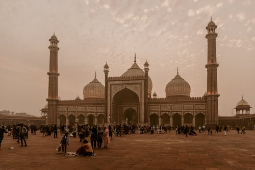A large mosque with many people standing around it